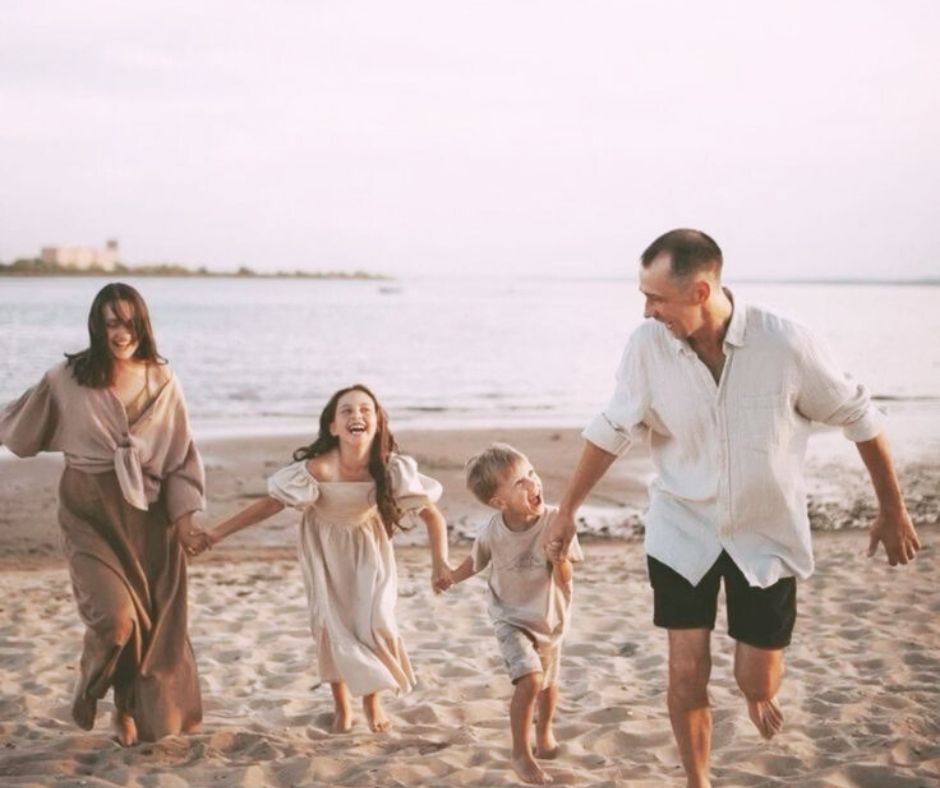 Glad familie løber på stranden. Forældrerådgivning i Randers.