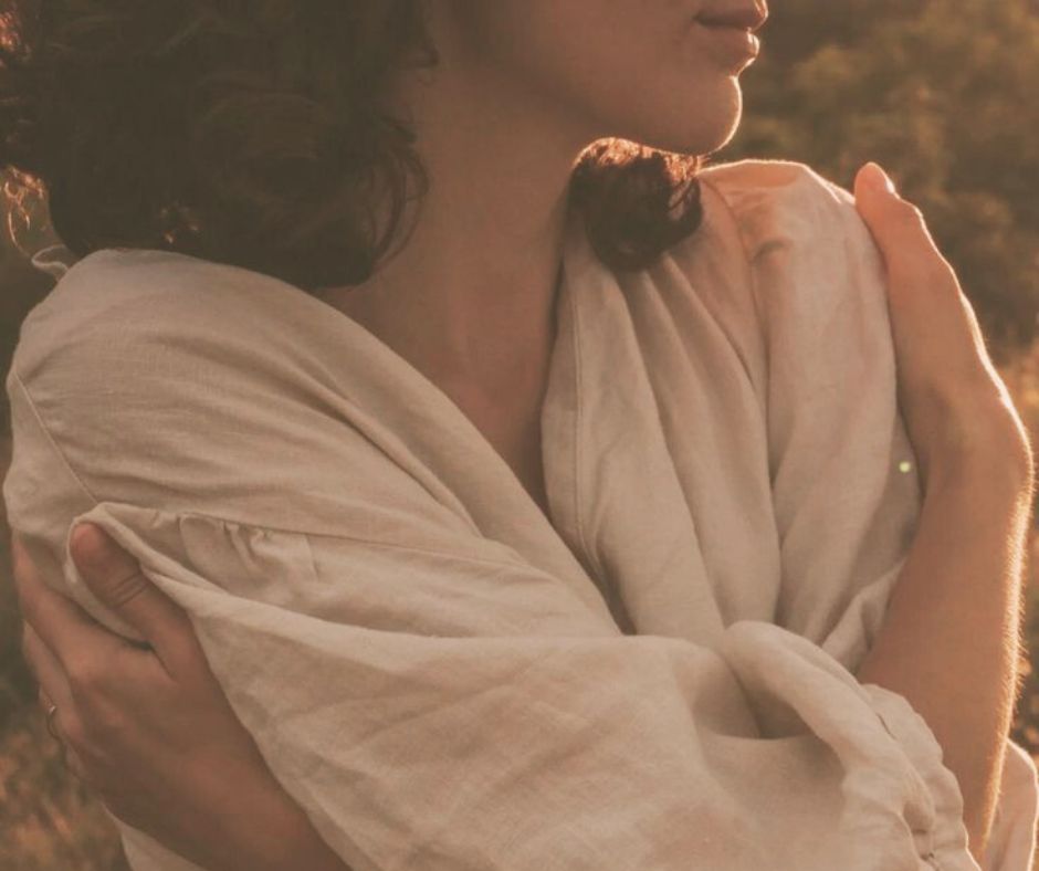 En kvinde holder om sig selv.