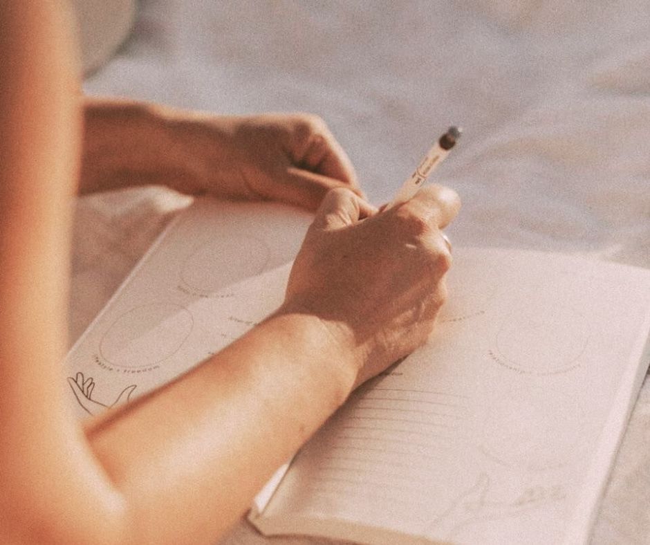 Kvinde skriver i notesbog. Terapi for børn.