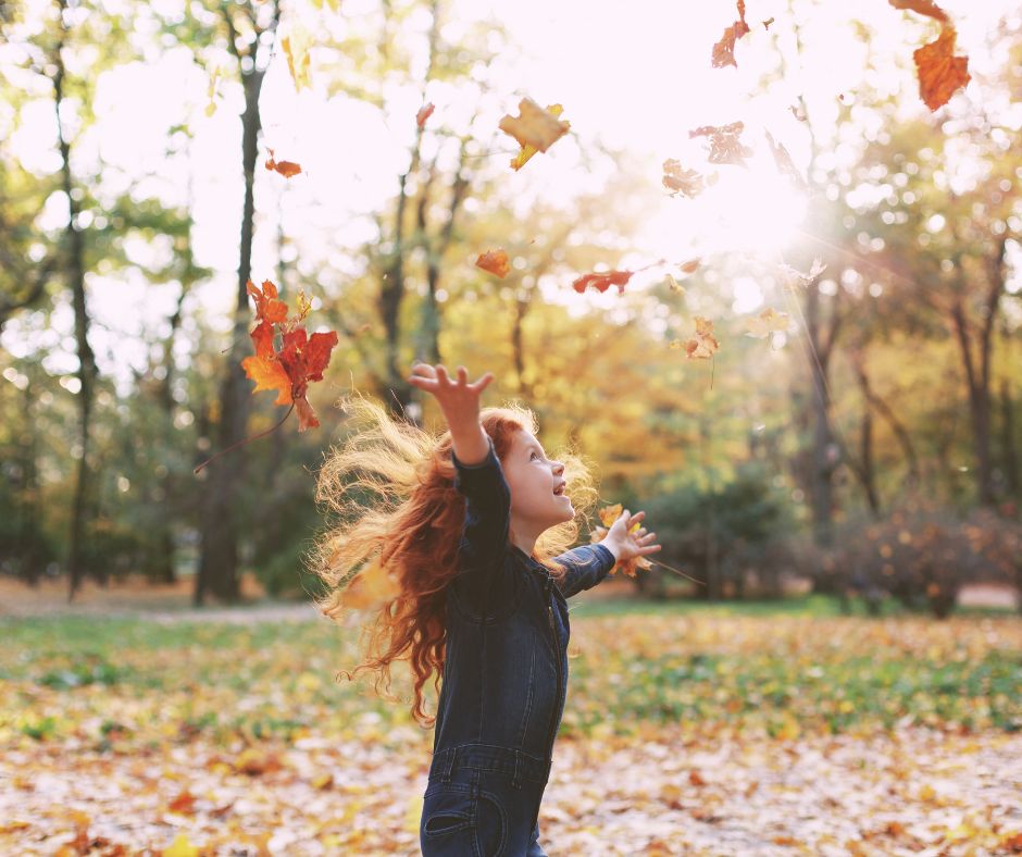 Lille pige kaster med blade. Terapi for børn.